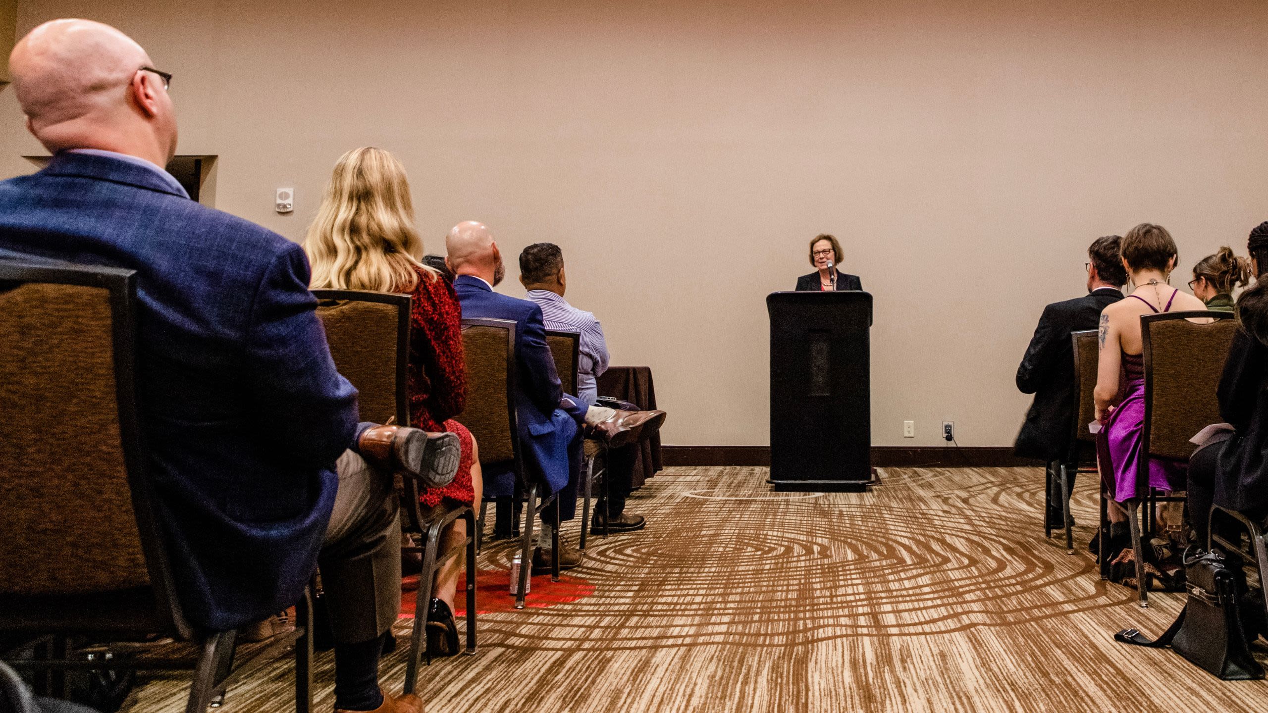 woman speaking at podium to an audience