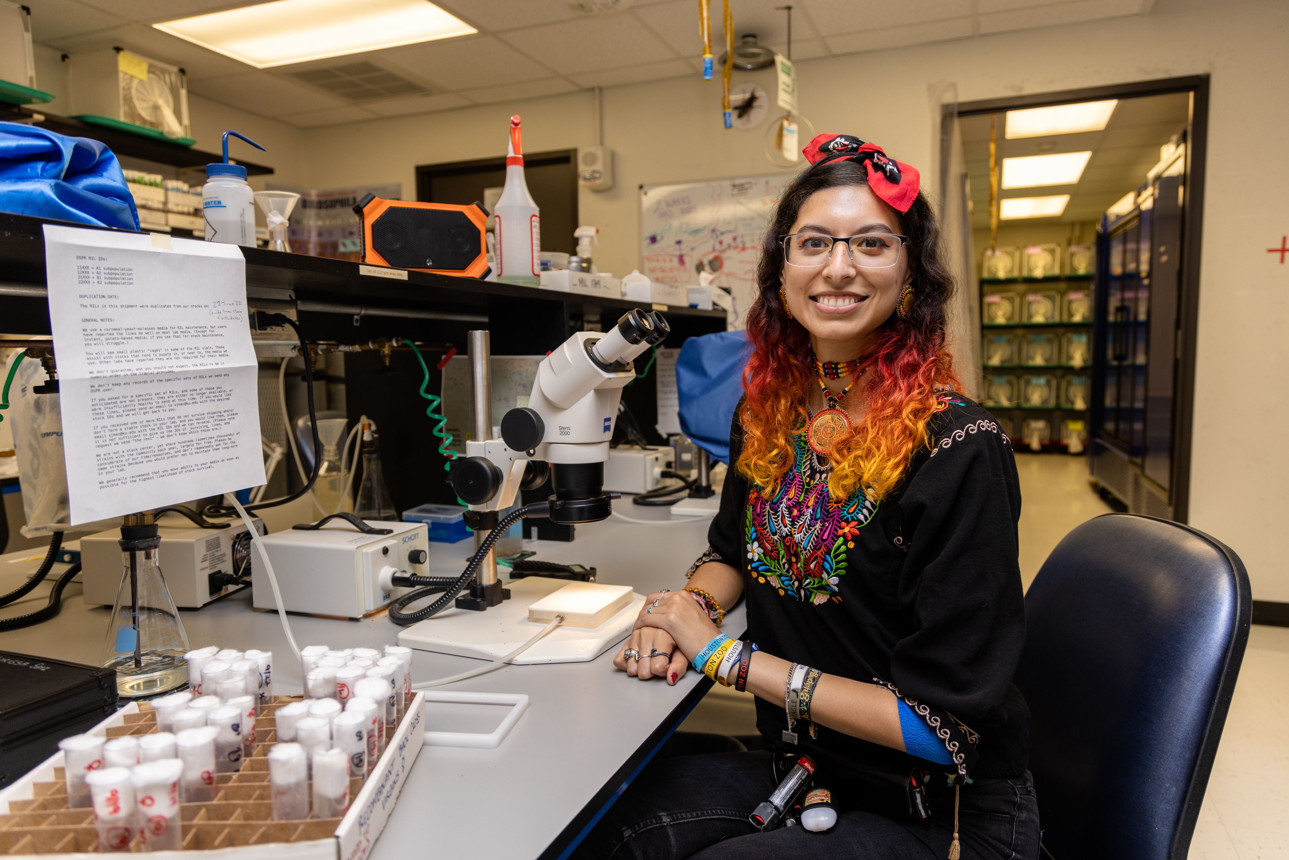 Female student in black dress sitting in a lab