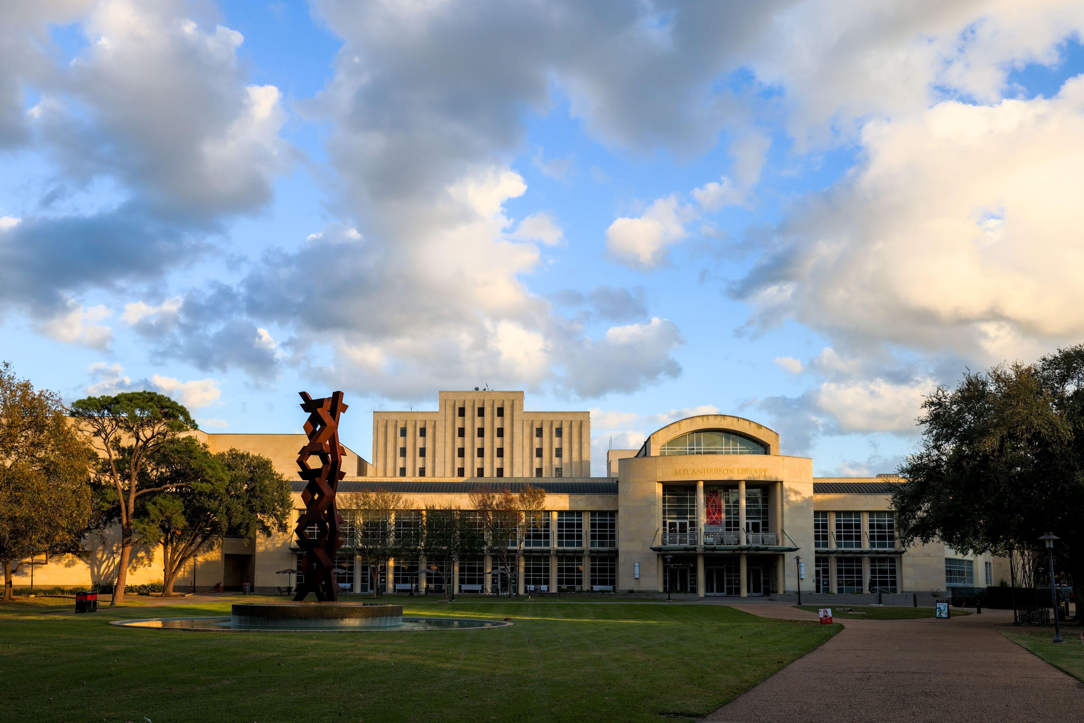 MD Anderson Library on the University of Houston campus with some clouds above in an otherwise blue sky.