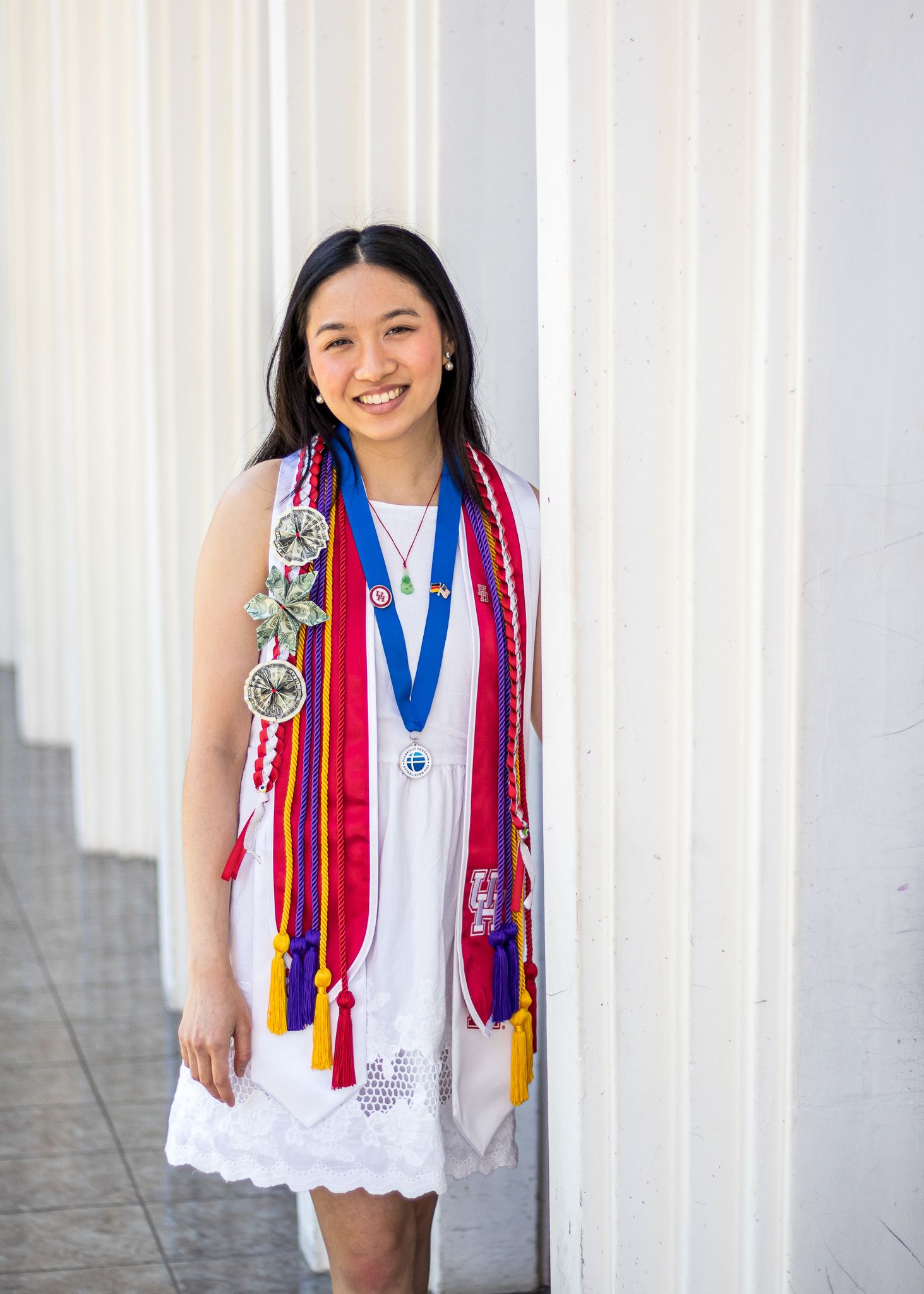girl wearing white dress with graduation cords